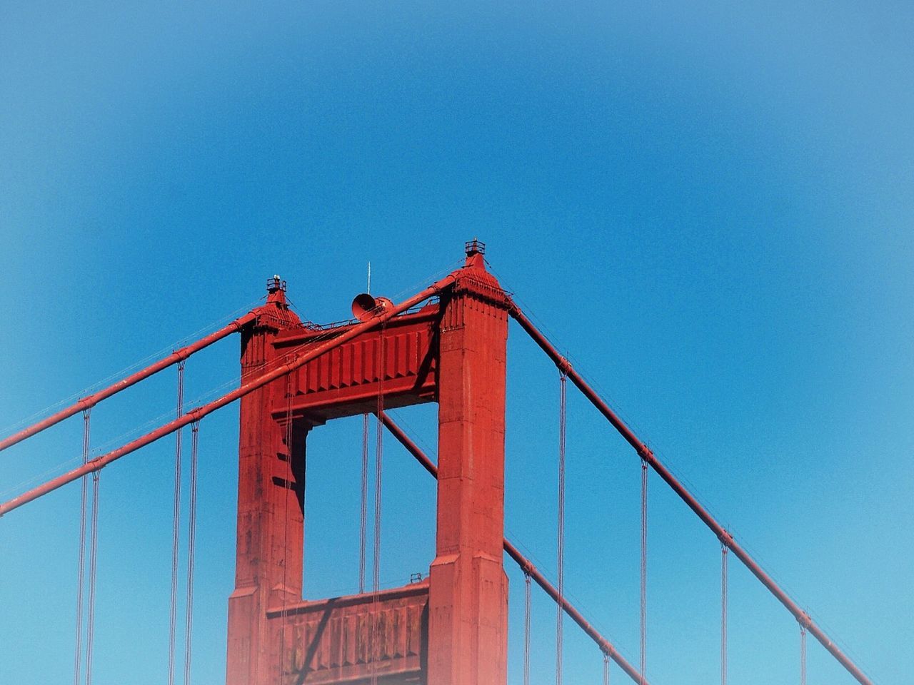 clear sky, built structure, architecture, low angle view, copy space, blue, connection, bridge - man made structure, red, building exterior, engineering, metal, suspension bridge, bridge, outdoors, no people, day, high section, sky, metallic