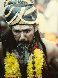 Close-up portrait of man with yellow flower