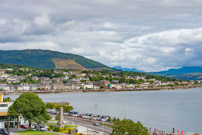 High angle view of city by mountain against sky