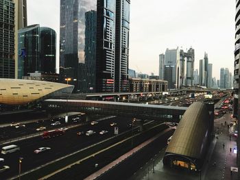 Traffic on road by buildings against sky in city