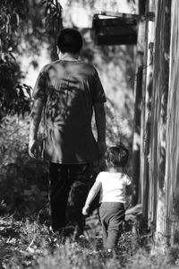 Rear view of father walking outdoors