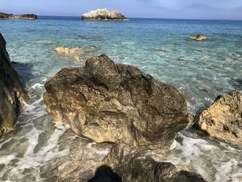 Scenic view of rocks in sea against sky