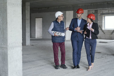 Businessman colleagues discussing with architect at site