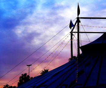 Low angle view of silhouette cranes against sky