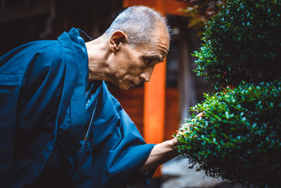 Side view of man looking at plants