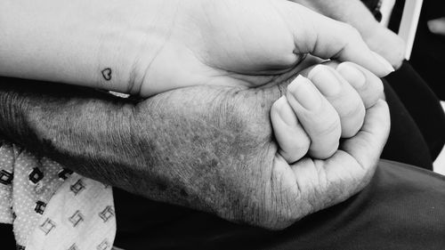 Low section of father holding baby hand