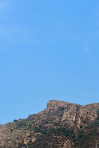 Low angle view of mountains against clear blue sky