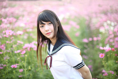 Young woman standing amidst flowering plants