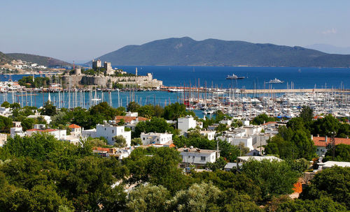 High angle view of city by sea against sky