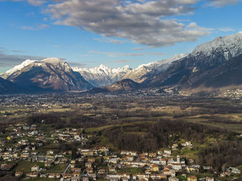 Aerial view of townscape and mountains against sky