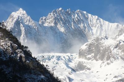 Fog over snowcapped mountain range