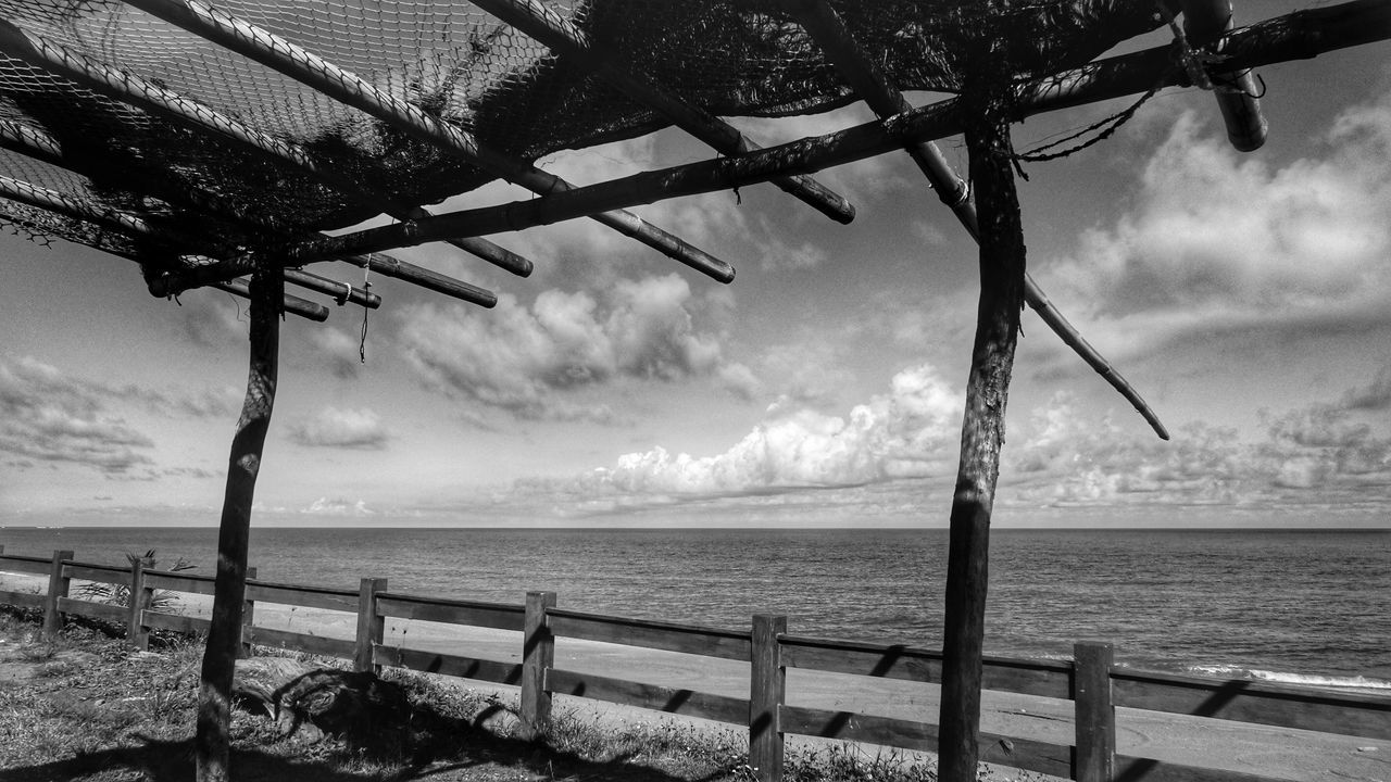 sea, water, sky, horizon over water, cloud - sky, tranquility, railing, scenics, fence, nature, tranquil scene, cloudy, beauty in nature, shore, beach, weather, cloud, outdoors, idyllic, protection