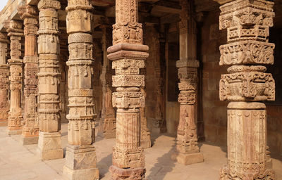 Columns with stone carving in courtyard of quwwat-ul-islam mosque, qutub minar complex, delhi, india