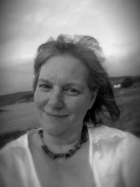 Portrait of smiling woman at beach against sky