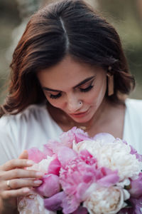 Close-up of woman holding pink flower bouquet