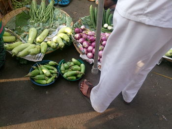 Low section of man buying vegetables at street market