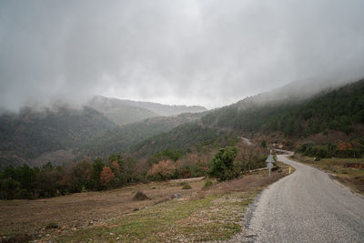 Road by mountains against sky