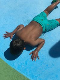 High angle view of boy lying in swimming pool