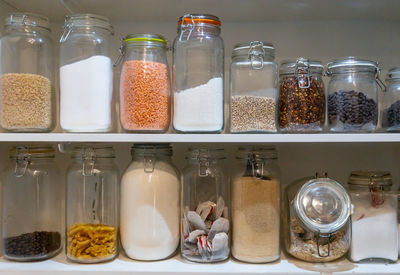 Various fruits in glass jar on shelf