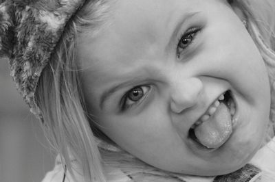 Close-up portrait of cute girl sticking out tongue