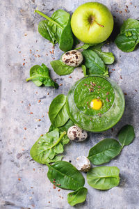 High angle view of spinach smoothie in container on marble