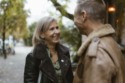 Happy mature woman on date with man near restaurant