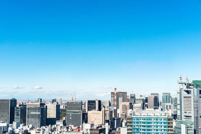 Buildings in city against blue sky