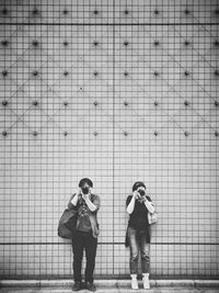 Full length of man photographing against sky