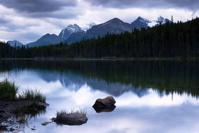 Scenic view of lake by mountains against sky