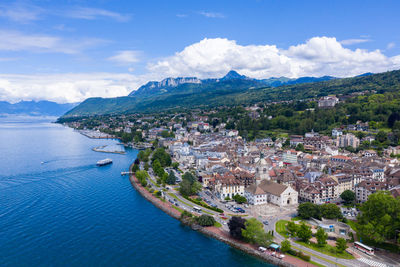 High angle view of townscape by sea against sky