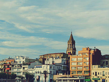 Buildings against cloudy sky