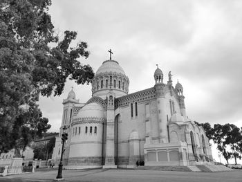 Low angle view of the basilica of our lady of africa against cloudy sky