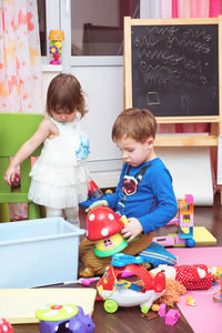 Siblings playing with toys at home
