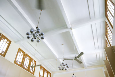 Low angle view of illuminated chandelier hanging on ceiling