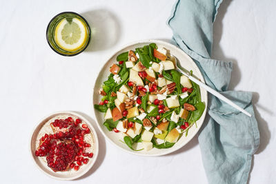 Fruits salad with nuts, balanced food, clean eating. spinach with apples, pecans and feta, garnished