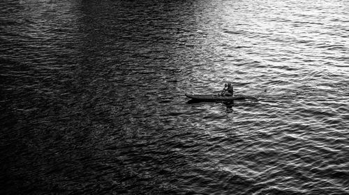 Sailing from light into the darkness. high angle view of sailor on canoe boat sailing