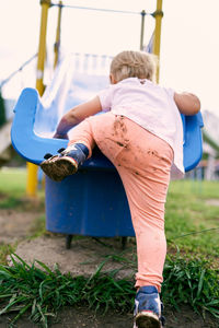 Rear view of girl playing on playground