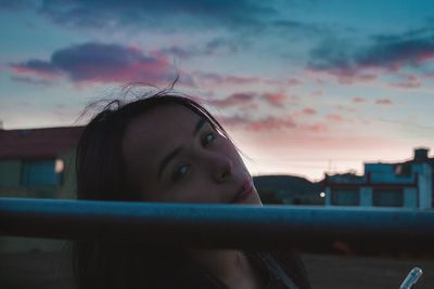 Portrait of woman looking away against sky during sunset