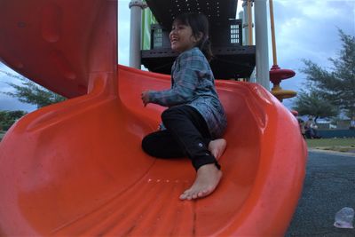 Boy sitting on slide at playground