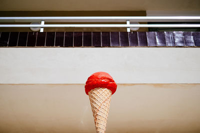 Close-up of red ice cream advertising against white wall