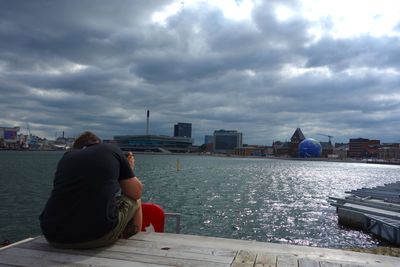 Rear view of woman sitting on boat in sea