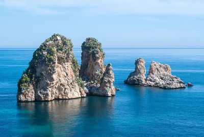 Scenic view of rocks in sea against sky