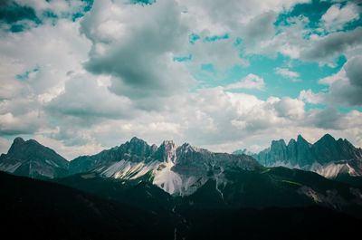 Scenic view of snowcapped mountains against cloudy sky