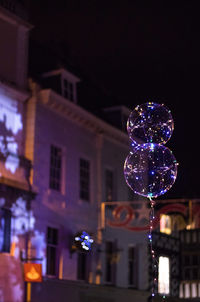 Low angle view of illuminated lights hanging at night