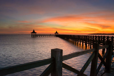 Pier over sea against sky during sunset