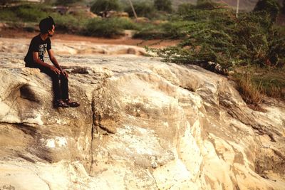 Side view of woman on rock