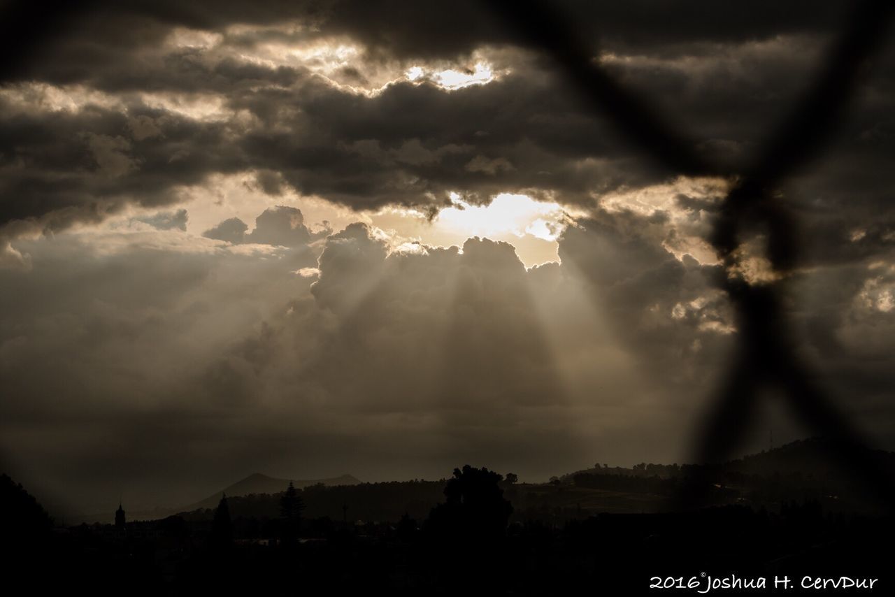 sunbeam, silhouette, cloud - sky, sunlight, sky, storm cloud, scenics, cloudscape, dark, cloud, majestic, dramatic sky, cloudy, beauty in nature, streaming, nature, rays, outdoors, atmospheric mood, day, tranquility, tranquil scene, atmosphere, outline, ethereal, back lit