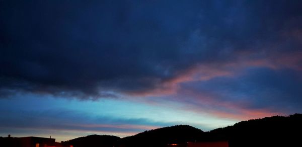 Scenic view of dramatic sky over silhouette landscape