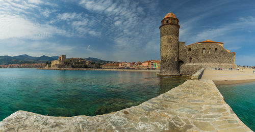 Historic building by sea against sky
