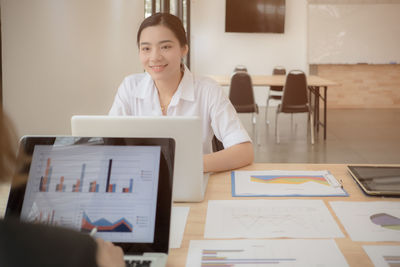 Businesswoman using laptop on desk in office